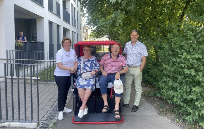 Testen die neue Fahrradrikscha (v.l.n.r.): Hausleitung Chrissi Pimenidou, eine Bewohnerin, Michael Hahn vom Krankenpflegeverein