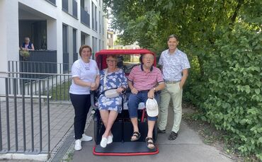 Testen die neue Fahrradrikscha (v.l.n.r.): Hausleitung Chrissi Pimenidou, eine Bewohnerin, Michael Hahn vom Krankenpflegeverein 