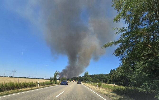 Eine Rauchsäule steigt am Fahrbahnrand der B36 in Linkenheim-Hochstetten auf.
