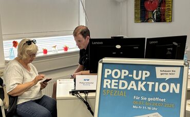 Eine Abonnentin wird von Philipp Schleicher in der Pop-up-Redaktion spezial beraten - an den anderen Schreibtischen im Erdgescho