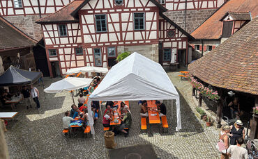 Besucher genießen Kaffee und Kuchen im Burgcafé auf Burg Reichenberg bei Oppenweiler.