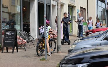 Der enge Gehweg an der Paulinenstraße zwischen "Glückskind" und "Skurril": Ein Radler bergauf, zwei E-Scooter bergab. Kinder bis