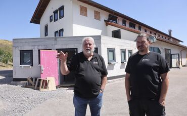 Manfred  (links) und Markus Amberger im Hof der Kelter mit ihrem Anbau für die Toiletten.
