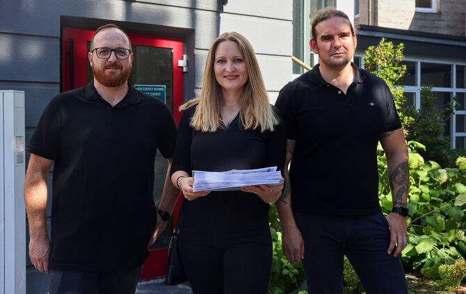 Conrad Zeller (l.), Bianca und Michael Haas mit den gesammelten Unterschriften vor der Übergabe im Rathaus.