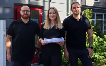 Conrad Zeller (l.), Bianca und Michael Haas mit den gesammelten Unterschriften vor der Übergabe im Rathaus.