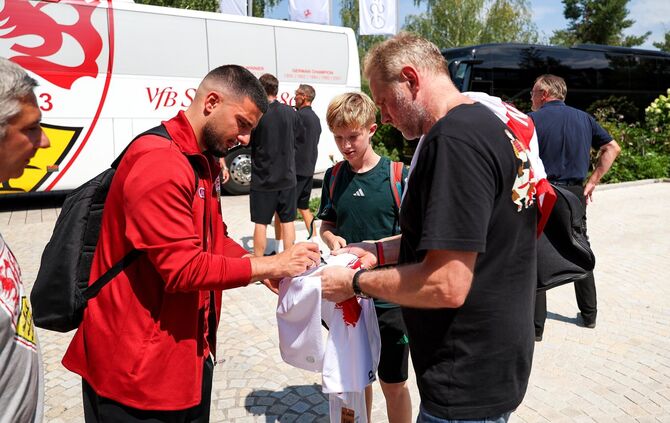 Deniz Undav schreibt vor dem Hotel Autogramme.