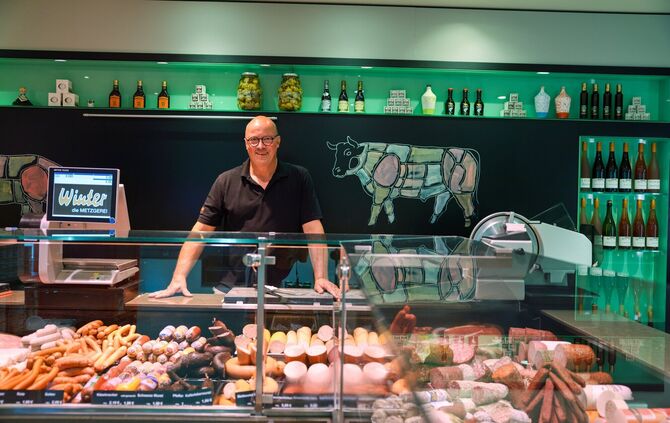 So kennen ihn seine Kundinnen und Kunden: Metzgermeister Frank Winter hinter der Theke mit den Fleisch- und Wurstwaren.