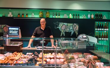 So kennen ihn seine Kundinnen und Kunden: Metzgermeister Frank Winter hinter der Theke mit den Fleisch- und Wurstwaren.