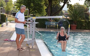 Ganz schön entspannt: Uli Netzer vom Freibadförderverein, wie er Badegast Kornelie Krause zum Test ins Wasser hievt.
