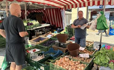 Harald Maier (rechts) verkauft Gemüse, Obst und Eier auf dem Wochenmarkt. Unter seinem Schirm staut sich die Hitze.
