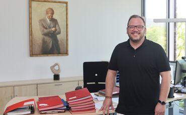 So hat sich Kevin Latzel in seinem Bürgermeister-Büro eingerichtet. Kennedy und Kunst an der Wand, Mappen voller Unterlagen, die