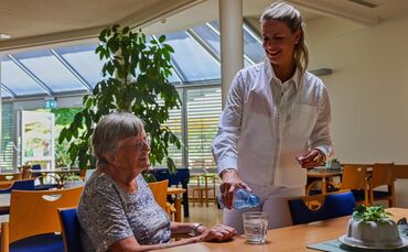 Viel trinken hat oberste Priorität: Hauptgeschäftsführerin Ulrike Brenner mit Bewohnerin Edeltraud Semet.