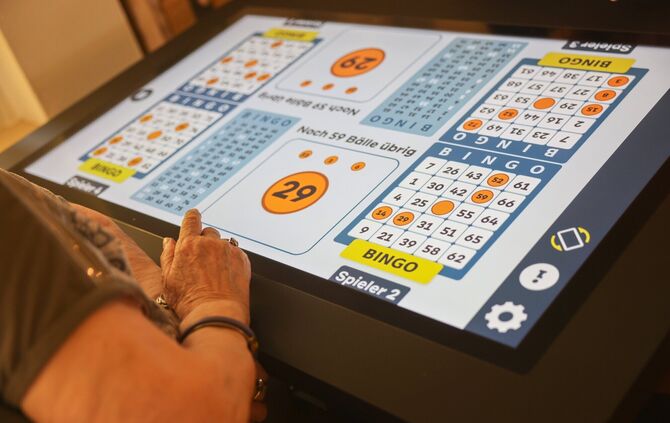 Im Haus im Schelmenholz tippen rüstige Senioren auf einem überdimensionalen Touchscreen.