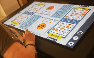 Im Haus im Schelmenholz tippen rüstige Senioren auf einem überdimensionalen Touchscreen.