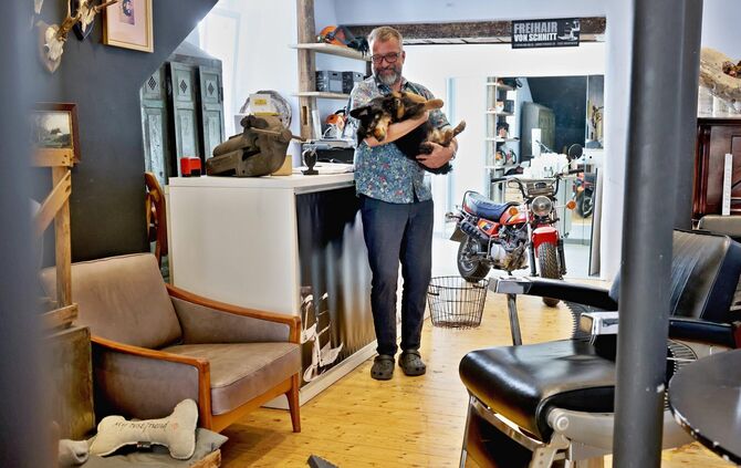 Ingo Knapper in seinem Friseurladen "Freihair von Schnitt" in der Langen Straße mit Hund Oskar.