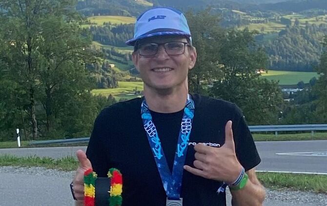 Jens Müller mit seiner Trophäe – die Besten ihrer Altersklassen erhalten beim Triathlon am Alpsee eine Allgäuer Kuhglocke.