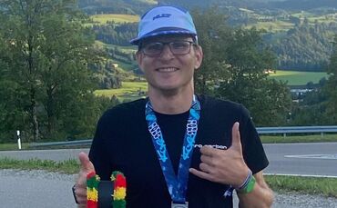 Jens Müller mit seiner Trophäe – die Besten ihrer Altersklassen erhalten beim Triathlon am Alpsee eine Allgäuer Kuhglocke.