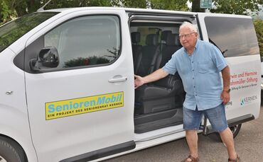 Rolf Deiß öffnet die Tür des Seniorenmobils, bereit für eine neue Fahrt durch Kernen.