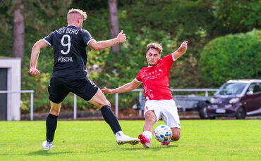 Leonis Buzhala vom SV Fellbach (in Rot) im Zweikampf mit Bergs Topstürmer Hannes Pöschl.