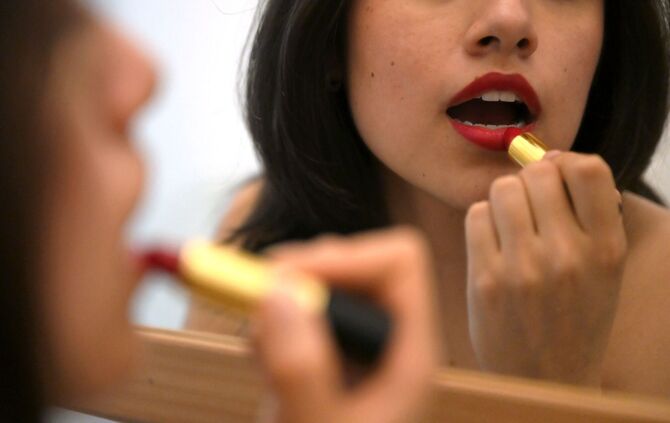 Lippenstift auftragen vor dem Spiegel