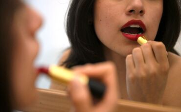 Lippenstift auftragen vor dem Spiegel