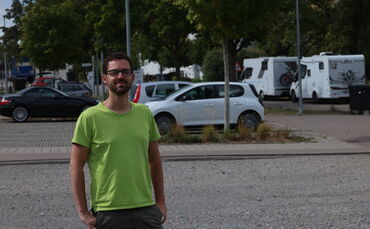 Sportpunkt-Geschäftsführer Patrick Entreß auf dem Schotterparkplatz unweit von Sportpunkt und Bike-Bahn: Die Wohnmobile stehen j