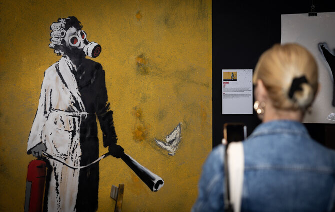 Das Original-Graffiti "Frau mit Gasmaske" ist in der Ukraine an einer Wand von Banksy gesprüht worden.
