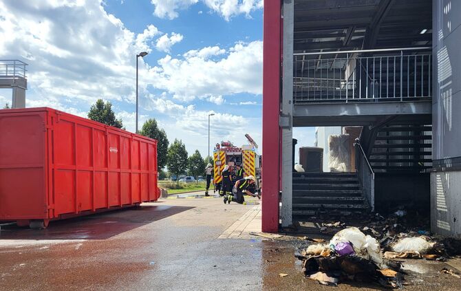 Verbranntes Gerümpel am Einsatzort. Die Feuerwehr ist schon mit Aufräumen beschäftigt.
