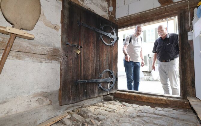 Jan Wölfl und Günter Brecht schauen sich in der alten Pfarrscheuer um. Hier der Blick in den ehemaligen Kuhstall mit Güllerinne.