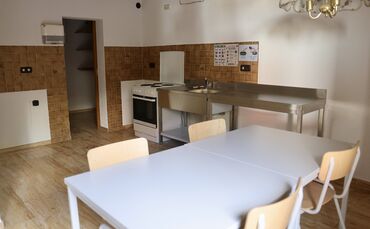 Einfacher Vier-Platten-Herd und Spüle: Gemeinschaftsküche mit Essbereich im ehemaligen Hotel Krone.