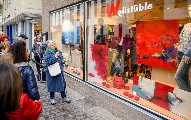 Eva Schwanitz bei der Kunstnacht-Führung vor einem Schaufenster, in dem Bilder ausgestellt sind (Archivfoto).