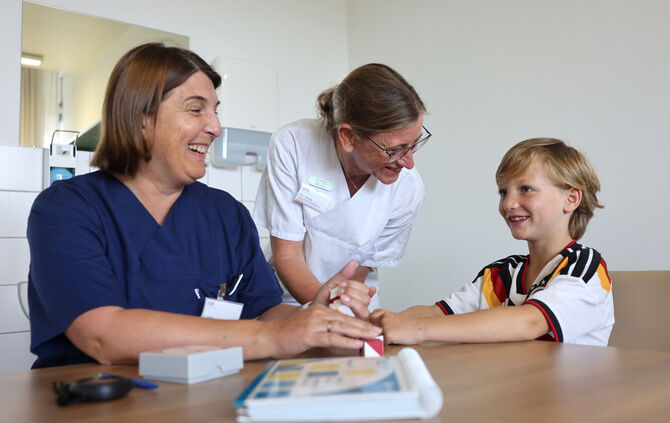 Neben Kinderpsychologin Saskia Vetter (links) und SPZ-Chefin und Kinderneurologin Dr. Iris Pross, stand der siebenjährige Oskar