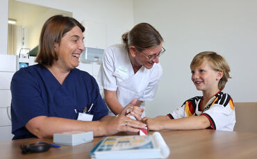 Neben Kinderpsychologin Saskia Vetter (links) und SPZ-Chefin und Kinderneurologin Dr. Iris Pross, stand der siebenjährige Oskar 