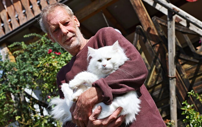 Flauschig, weiß und wieder bei guter Gesundheit: Kater Kiran mit seinem Retter Volker Hoschek.