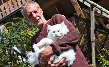 Flauschig, weiß und wieder bei guter Gesundheit: Kater Kiran mit seinem Retter Volker Hoschek.