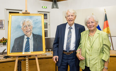 Der neue Ehrenbürger Friedrich Seibold, flankiert rechts von seiner Frau Karin und links seinem Ölgemälde von Jan Welker.