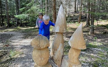 Eine der Aufgaben auf dem Grüffelo-Pfad: Eine Holzschlange windet sich zwischen Pilzen hindu  rch und lädt zum Balancieren ein.