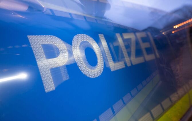 Polizei steht auf der Karosserie eines Polizeifahrzeugs
