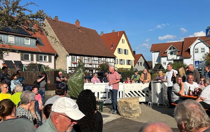 Überraschung: Noch ist der Brunnen verborgen, die Gäste warten gespannt auf die Enthüllung.
