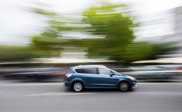 Auto fährt innerorts über eine Straße