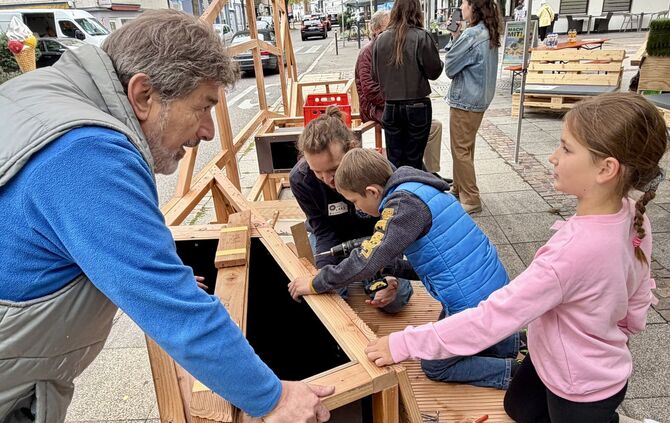 Jung und Alt beim Zusammenbauen der modularen Sitzlandschaft in der Fronackerstraße.