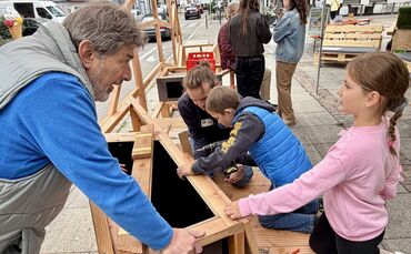 Jung und Alt beim Zusammenbauen der modularen Sitzlandschaft in der Fronackerstraße.