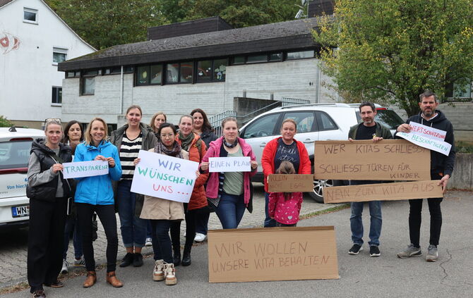 "Wir wollen unsere Kita behalten": Mit Plakaten protestieren Eltern gegen die geplante Schließung des katholischen Kindergartens