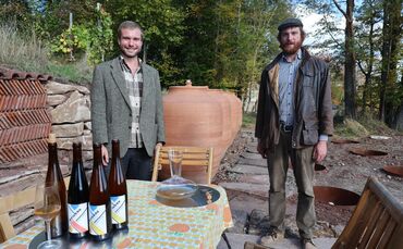 Richard (links) und Bernhard Mödinger vor den Amphoren, in denen sie ihren Wein ausbauen.