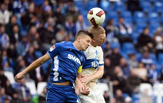 Alles Kopfsache: Karlsruhes Marvin Wanitzek (l) und Darmstadts Kai Klefisch im Duell um den Ball.