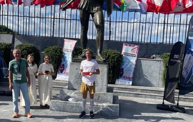 Julian Nassadil, mit Lorbeerkranz, bei Zeremonie an der Statue von König Leonidas in Sparta.