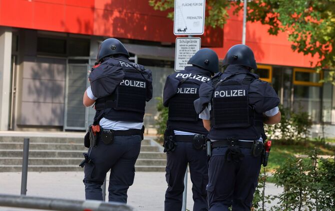 Polizeibeamte rennen in Schutzmontur aufs Büchner-Gymnasium zu - die große Übung der Polizei wiederholt sich am Ferien-Mittwoch