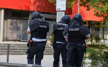 Polizeibeamte rennen in Schutzmontur aufs Büchner-Gymnasium zu - die große Übung der Polizei wiederholt sich am Ferien-Mittwoch
