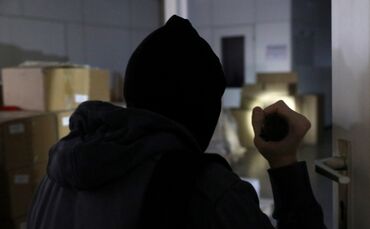Ein Einbrecher mit Taschenlampe (Symbolfoto).