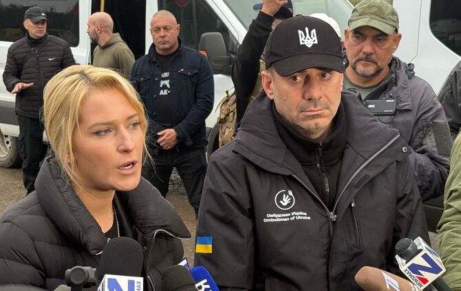 Die Menschenrechtsbeauftragten von Russland, Jana Lantratowa (l), und der Ukraine, Dmytro Lubinez (M, schwarze Kappe), können si